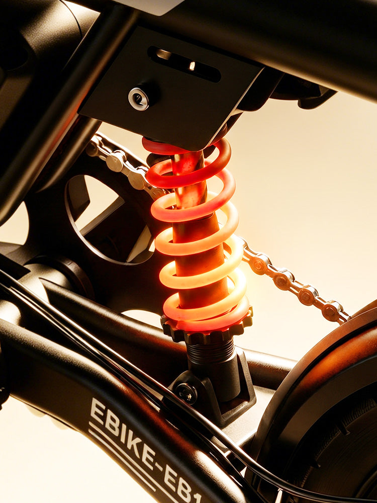 Close-up of the EB1S rear suspension system featuring a glowing orange coil spring and sleek black frame.
