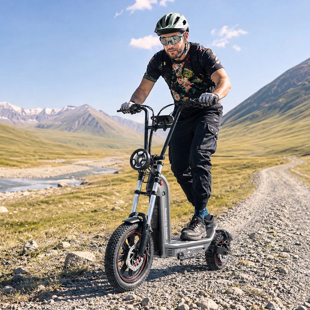 Rider wearing a helmet and protective eyewear riding the iScooter F7 Ultra electric scooter along a rugged mountain trail. The scooter features wide off-road tires, front suspension, and powerful braking, delivering a stable and comfortable ride across gravel paths and challenging outdoor terrain.