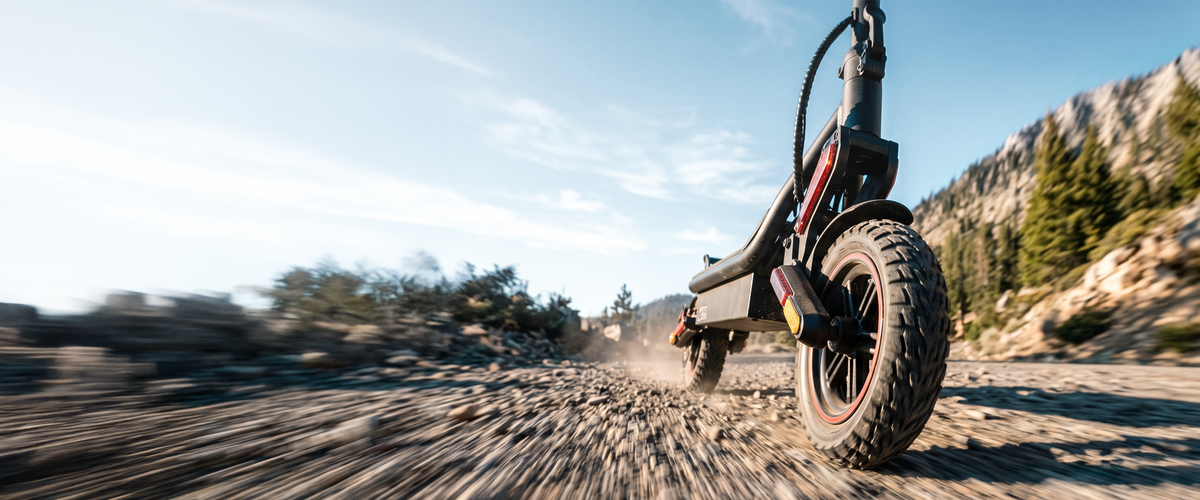 Off-road electric scooter riding along a dirt path in motion.