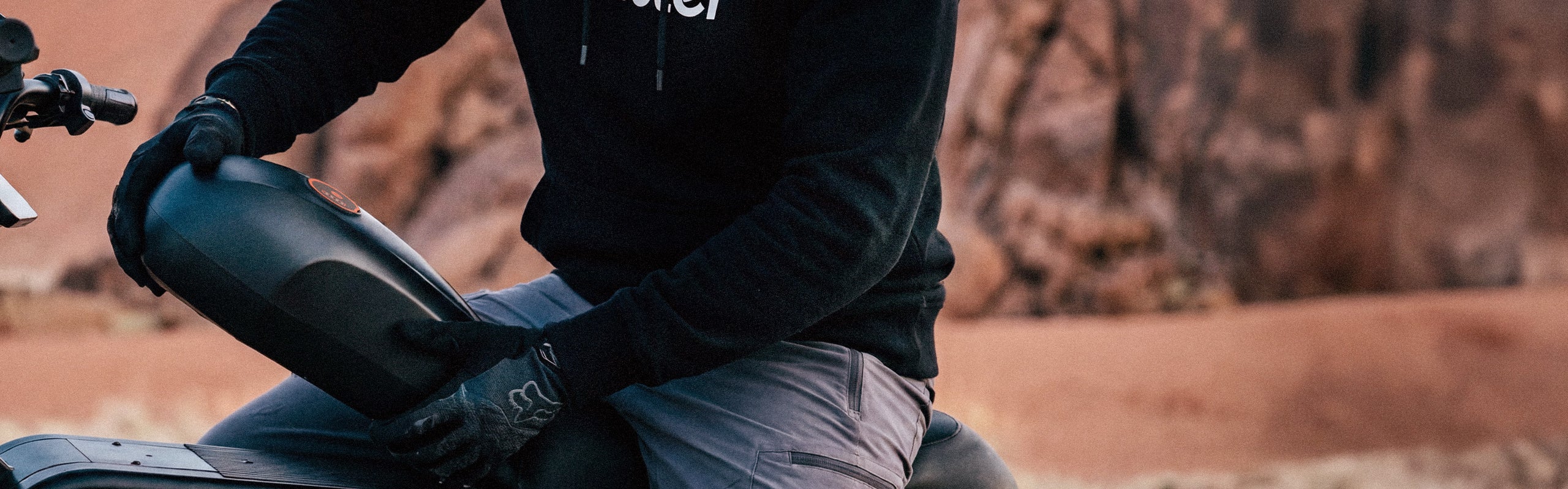 Person removing the detachable battery from the iScooter DX5 Max electric bike in an outdoor setting, demonstrating the bike’s easy battery removal design for convenient charging and maintenance.