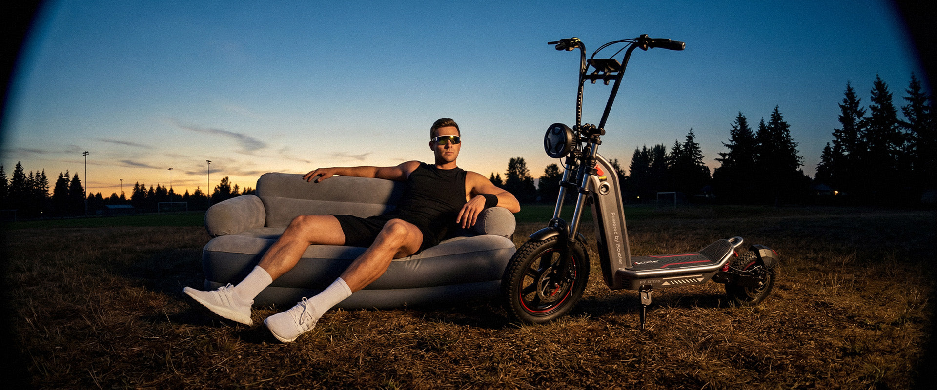 Man relaxing on a sofa outdoors beside F7 Ultra electric scooter at sunset, highlighting comfort and all-terrain lifestyle use