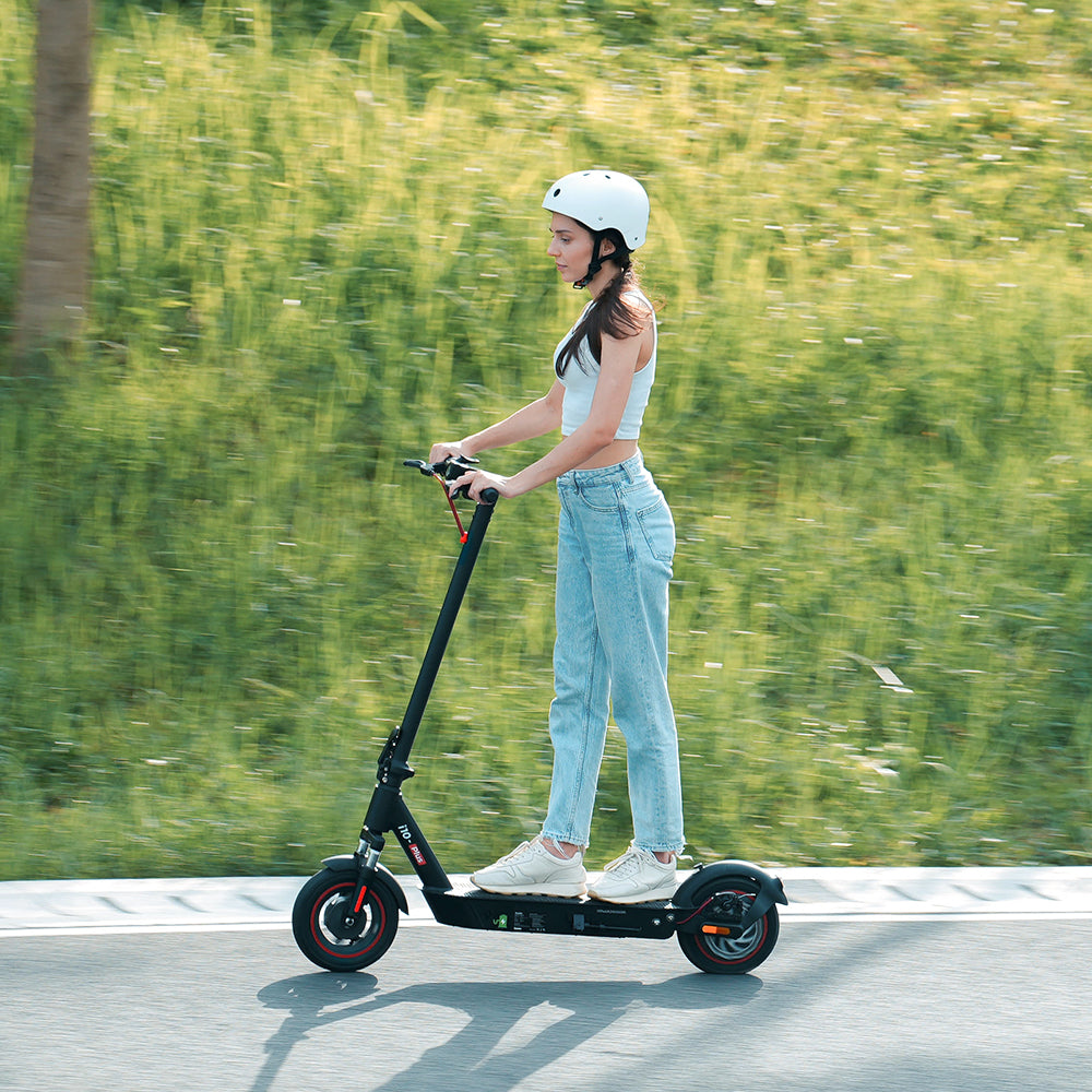 Person riding an electric scooter with iScooter branding and product features displayed.