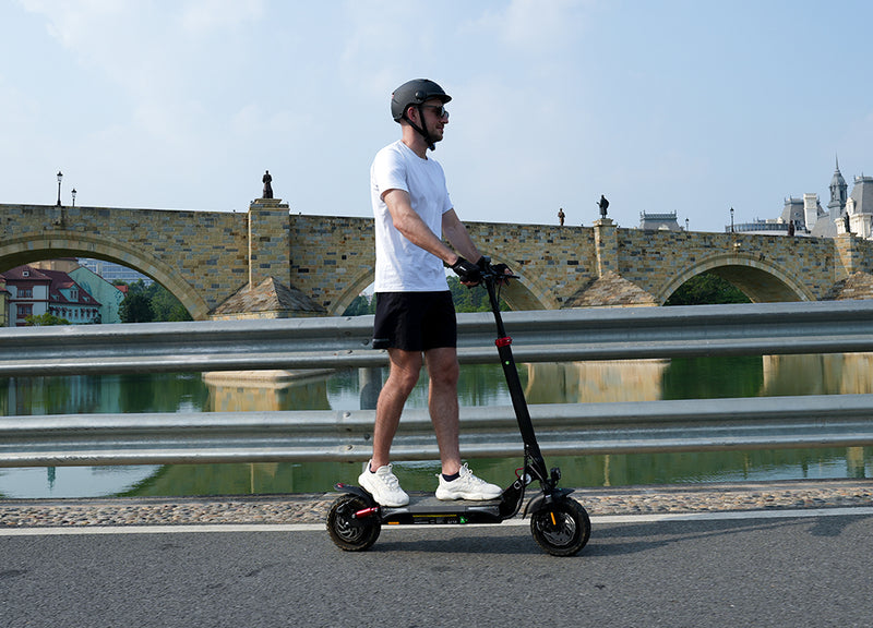 Person riding an electric scooter with iScooter branding and product features displayed.