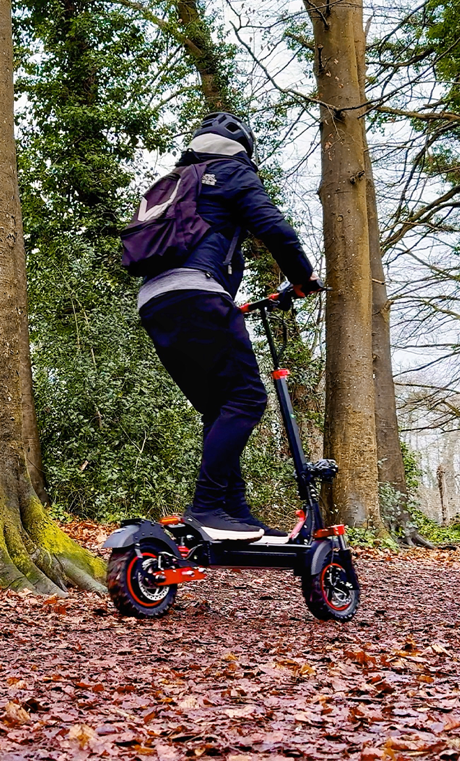 Person riding a scooter in a forest setting