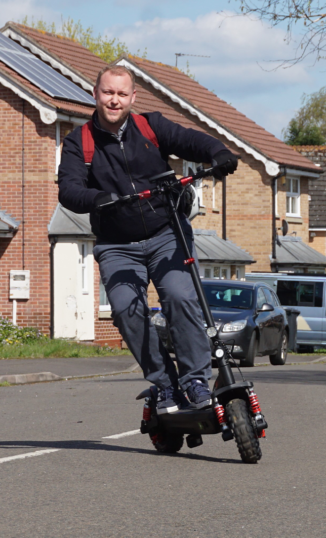 Person riding an electric scooter on a residential street