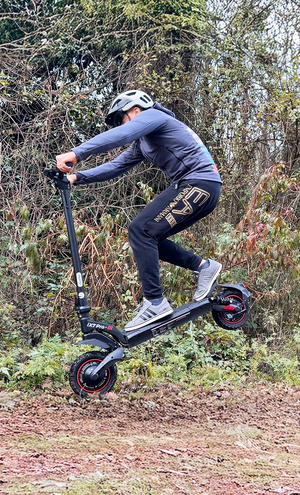 Person riding an electric scooter in a forested area