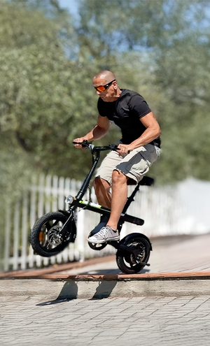 Man riding a small electric bike on a sidewalk with trees in the background