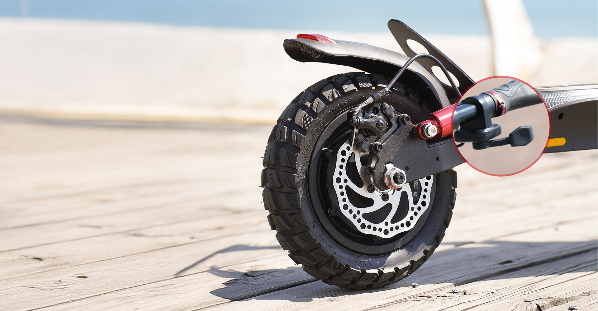 Wide-angle close-up of an electric scooter’s rear wheel featuring a disc brake system and suspension assembly, with a highlighted callout emphasizing the dual braking mechanism for improved stopping performance, control, and riding safety.