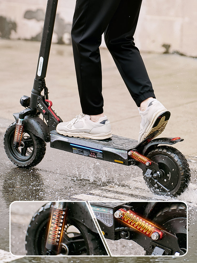 Rider standing on the iScooter iX3 electric scooter while traveling over wet pavement, with close-up inset views of the front and rear spring suspension system highlighting dual suspension for enhanced comfort, shock absorption, and stability on rough terrain.