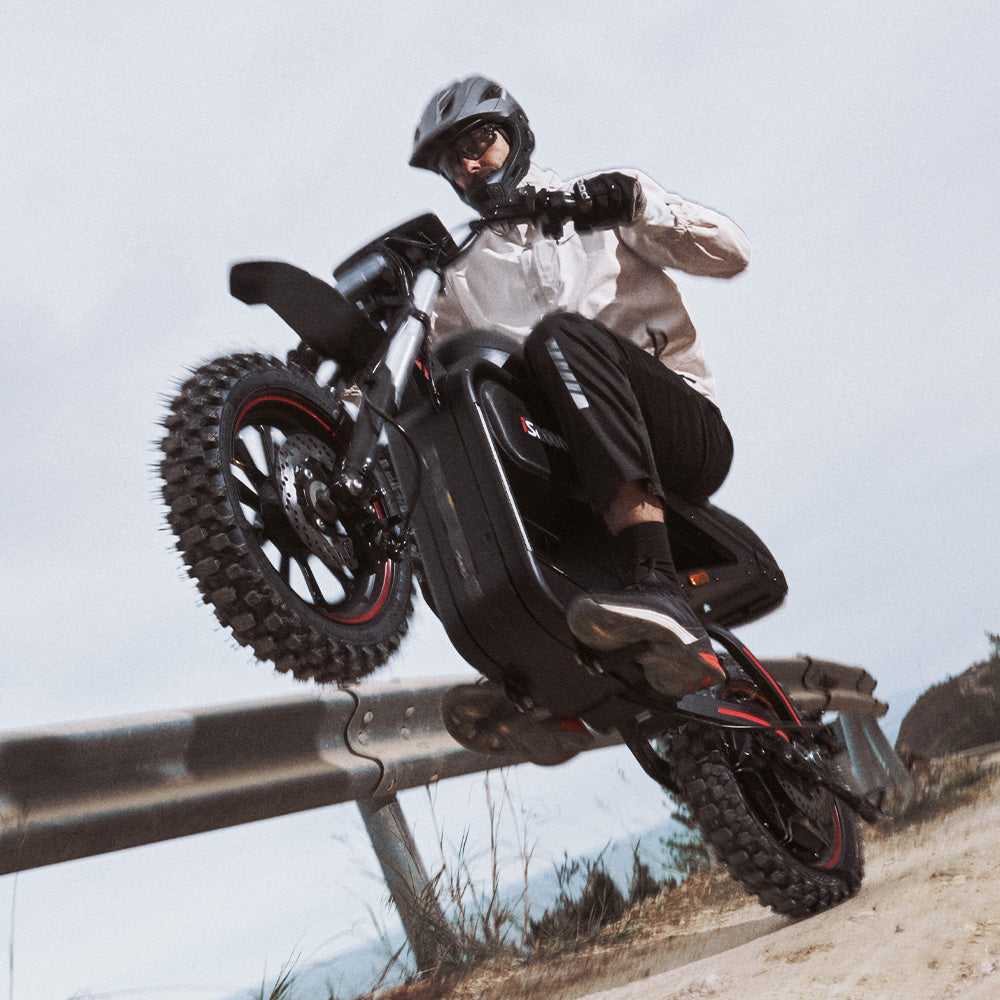 Rider maneuvering the iScooter DX5 Max electric bike over rough terrain, highlighting its off-road performance, fat tires, and agile handling during an action-packed ride.