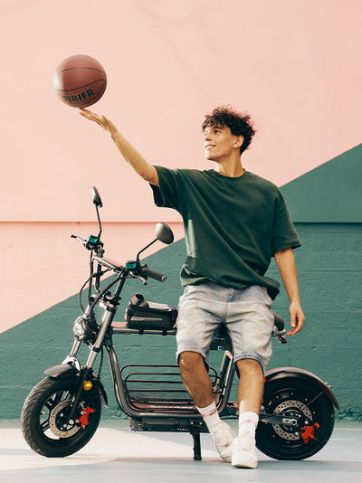 A side-view product dimension diagram of the DX5 electric scooter, overlaying red measurement labels for height, length, handlebar width, and storage space next to a leaning young man.