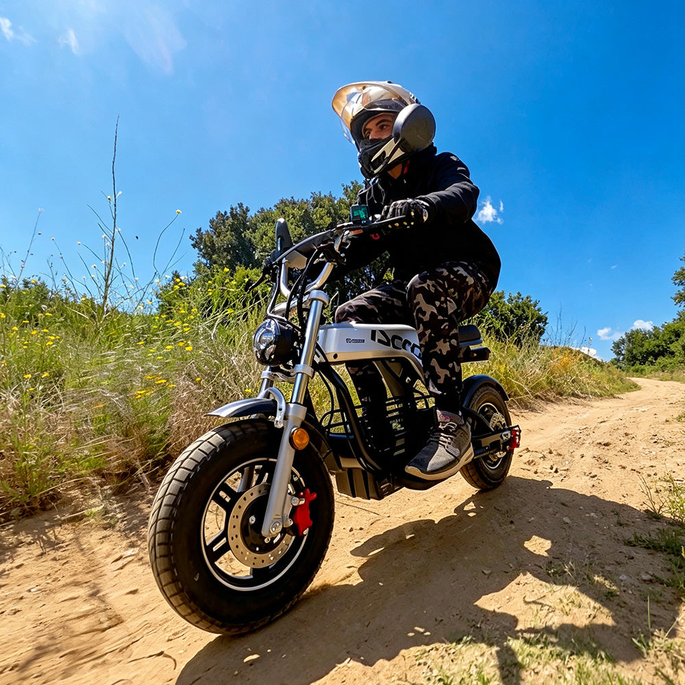 A rider wearing a helmet riding an iScooter DX5 Pro electric bike on a dirt trail.